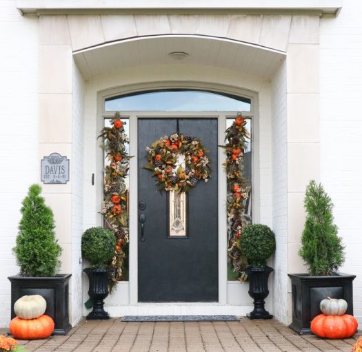 Open entryway decorated with artificial autumn foliage and pumpkins