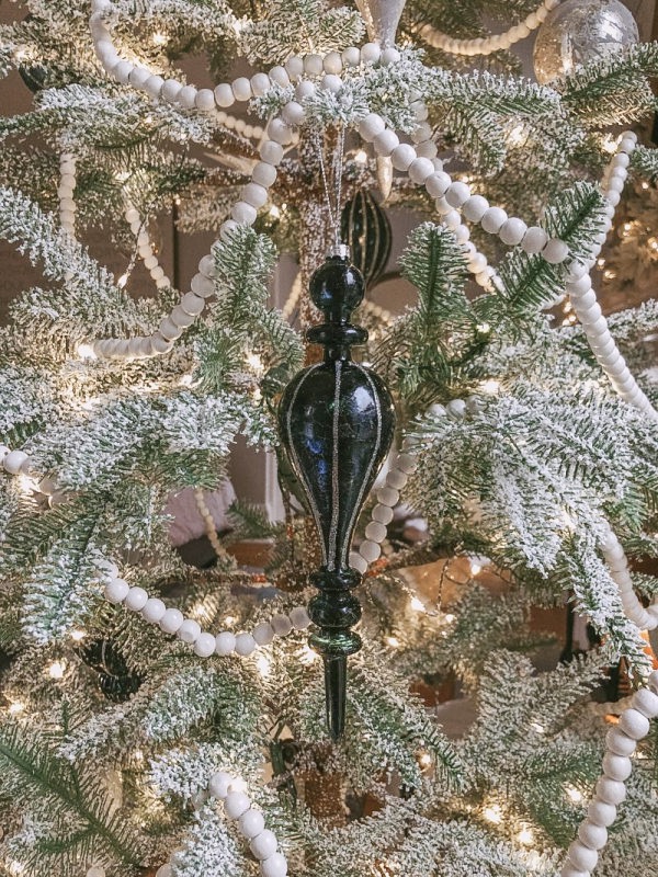 Midnight Frost glass ornament hanging on a tree