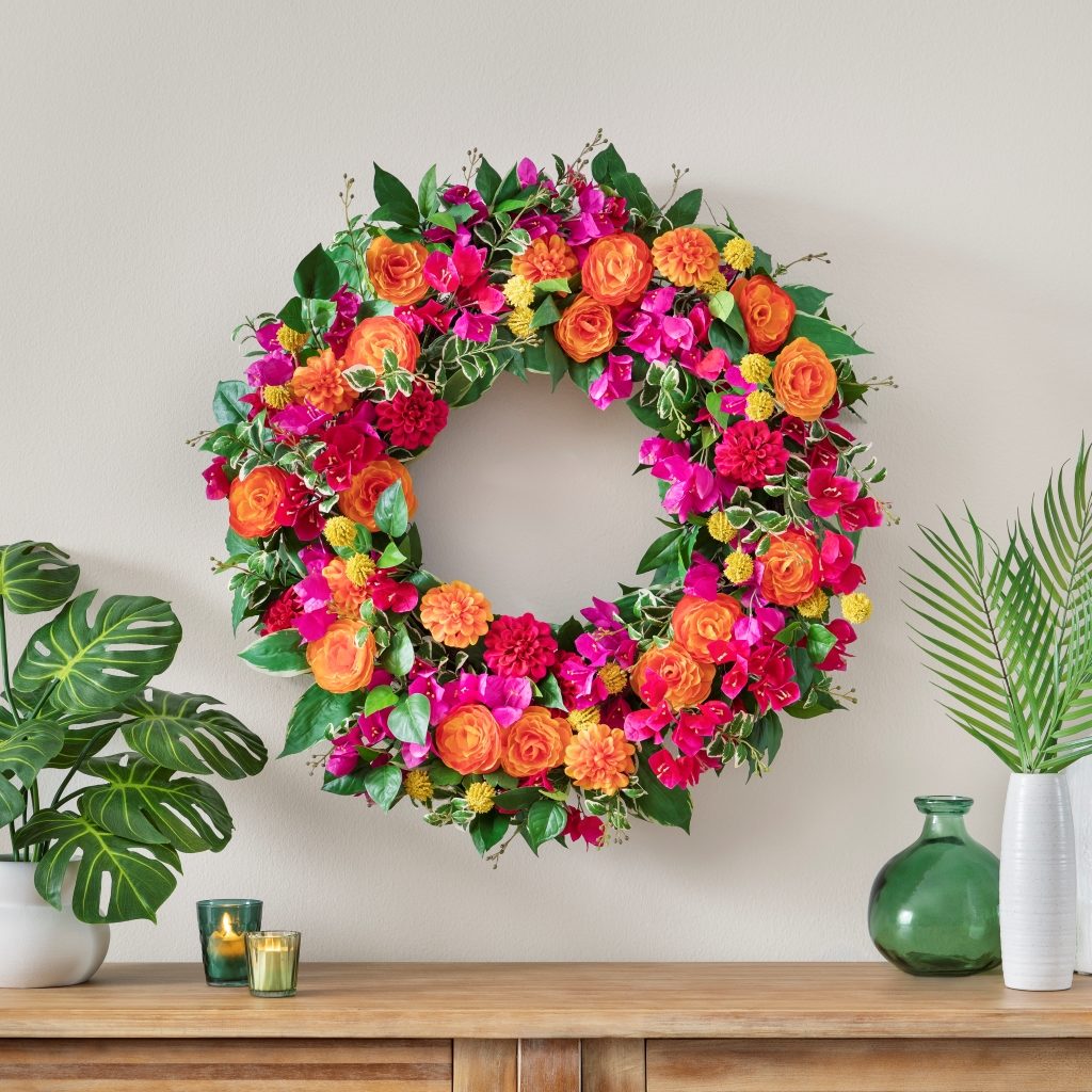 A floral wreath and indoor plants make good spring mantel decorations