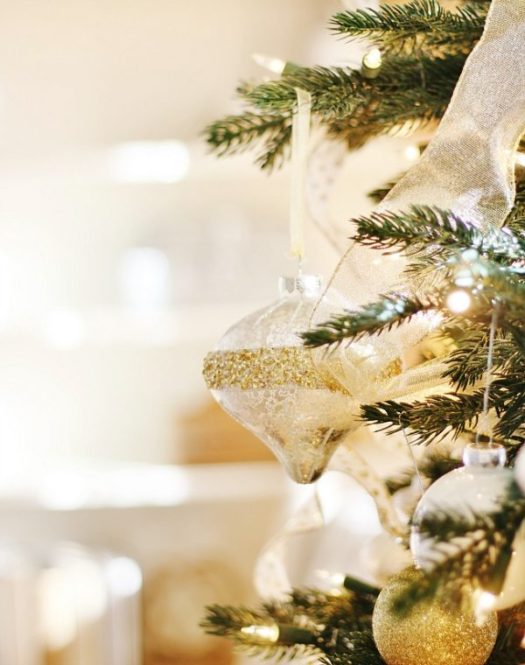 Closeup shot of a white and gold ornament hanging from a Christmas tree
