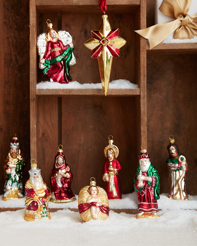 Assorted holiday figures lined up on a wooden shelf