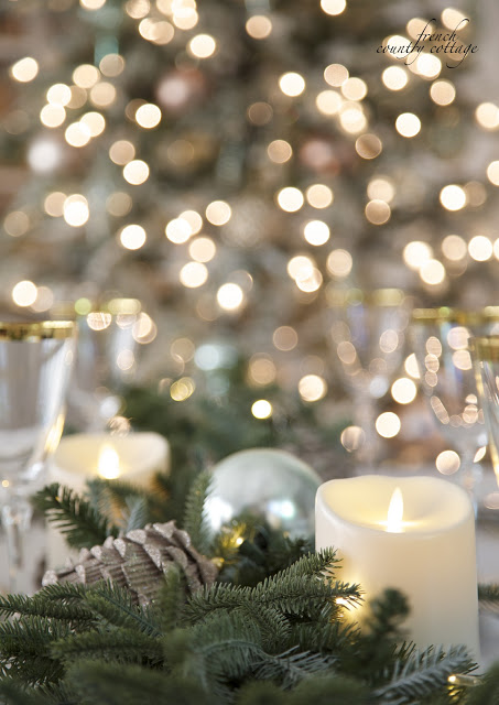Table set up with pinecone, evergreen foliage, and candles