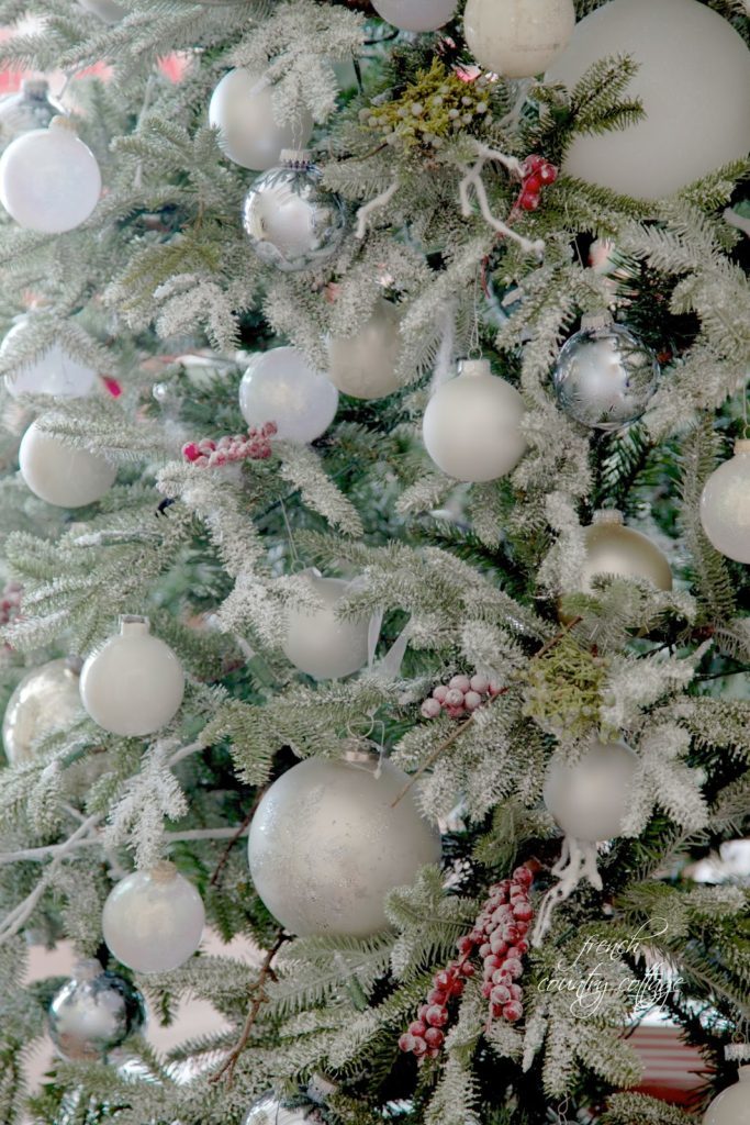 A cluster of white ornaments in different sizes for a simple rustic cottage frosted Christmas tree theme