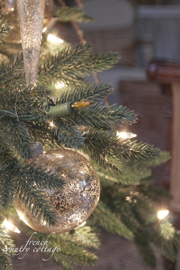 Close up of artificial Christmas tree, ornament, and lights