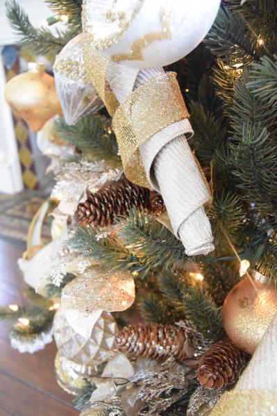 tree decorated with silver and gold ornaments and ribbons
