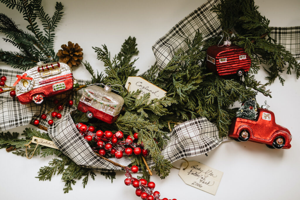 vintage-style truck ornaments, red berry picks, plaid ribbon, DIY wooden memory tags, evergreen foliage