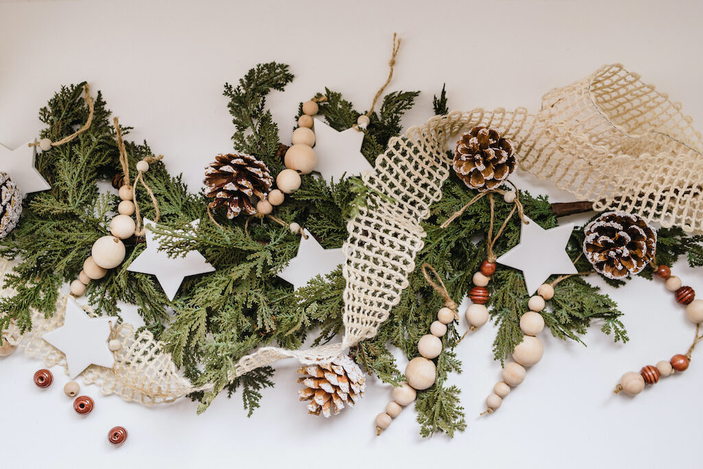 textured ribbon, evergreen foliage, pinecones, and wooden bead ornaments