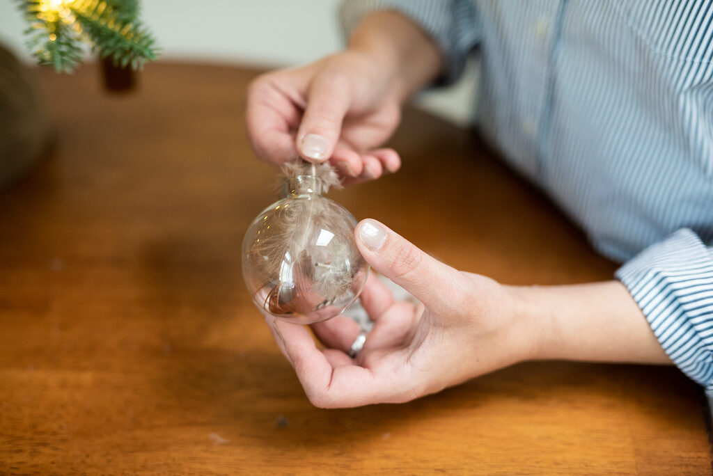 place feathers inside a glass ball ornament