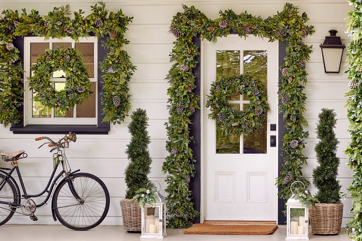 Greenery garland, wreaths, and topiaries in front porch
