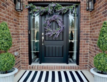 Photo of a front porch decorated with topiaries and lavender arrangements