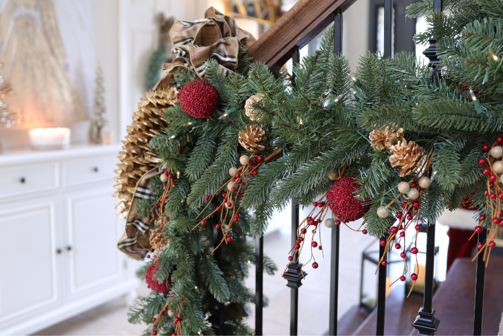 A Balsam Hill Vermont White Spruce Bordeaux Christmas garland hung on the staircase banister