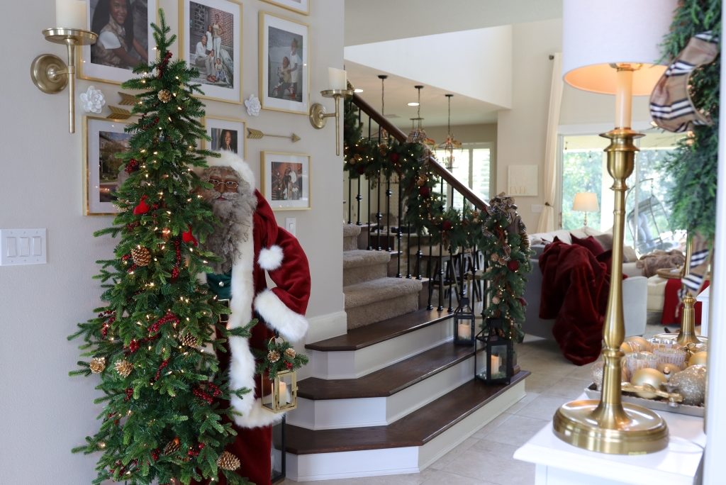 A life-size Santa and a pre-lit Christmas tree in the front entryway