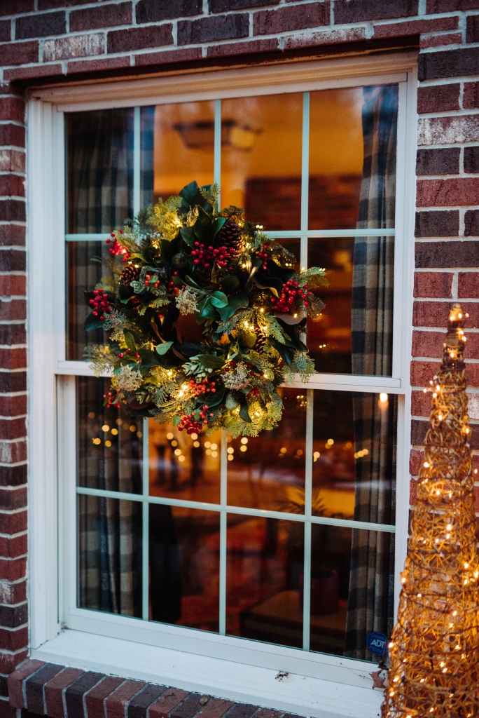 An outdoor Christmas wreath hung on a window
