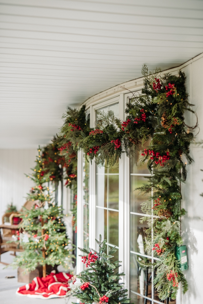 Balsam Hill Outdoor Red Berry Pine Garland hung on front porch windows