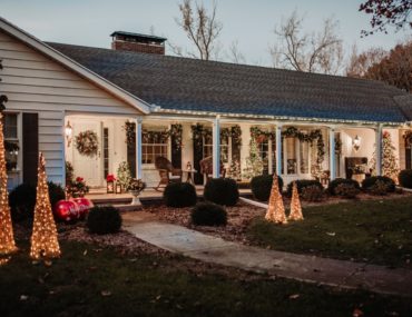Front yard and porch decorated with large outdoor lighted Christmas decorations