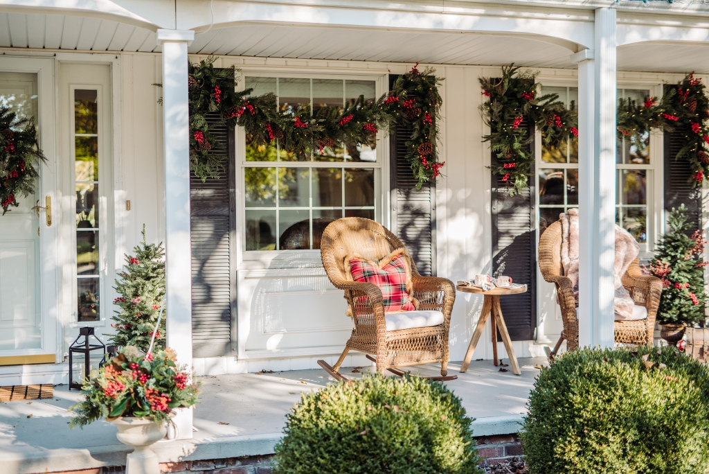 Front porch decorated with rocking chairs and Christmas garlands