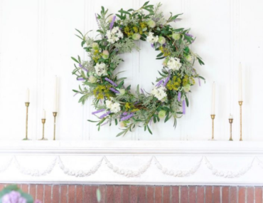 Floral wreath and taper candles on top of a mantel