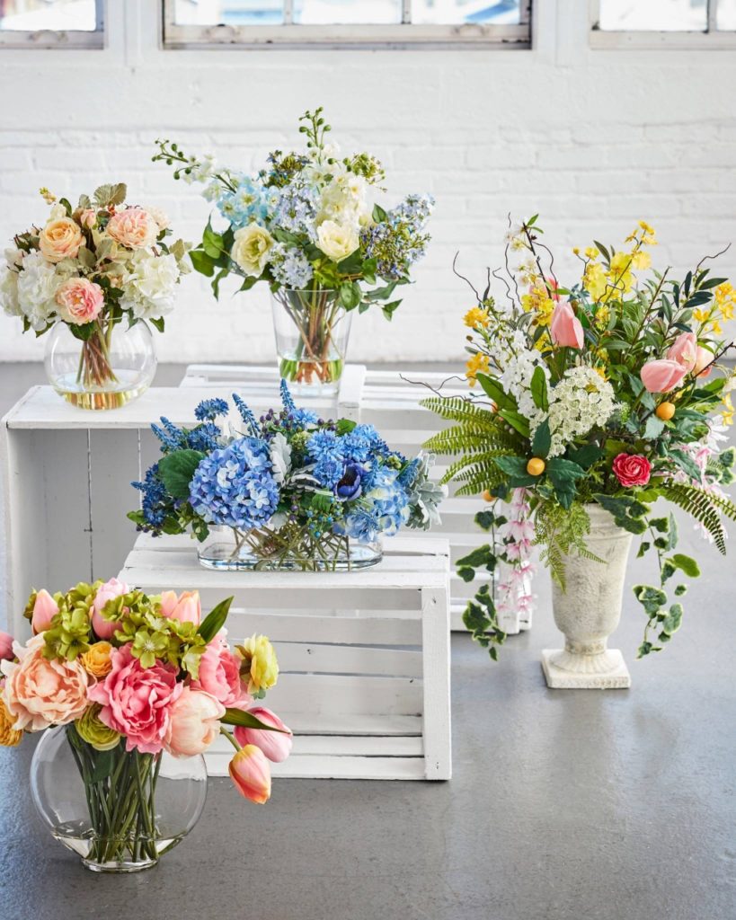 A collection of flower arrangements in different containers