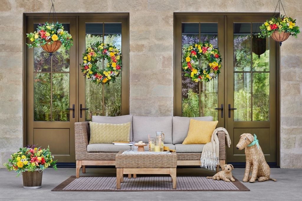 Photo of a decorated porch with spring florals and woven seagrass pups