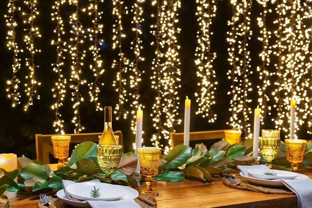 Al fresco table setup with hanging outdoor string lights backdrop