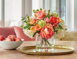 Orange and peach flower arrangement on top of a table