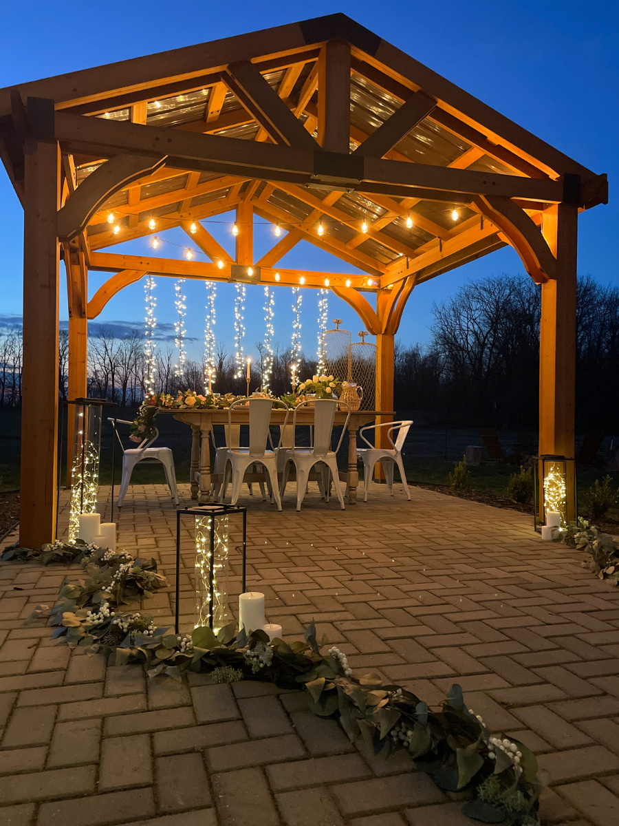Floral garland with lanterns, candles, and micro LED string lights as outdoor wedding decoration ideas