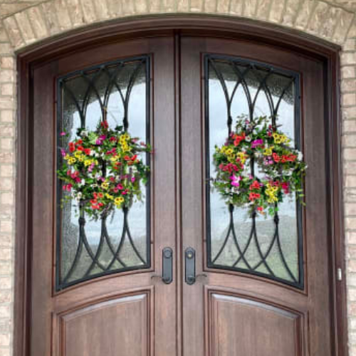 A pair of Balsam Hill Outdoor Meadow Wreaths hung on double doors regarded as one of the best quality artificial flowers