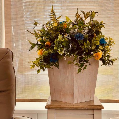 Balsam Hill Outdoor Summer Breeze Potted Foliage Arrangement on top of a side table
