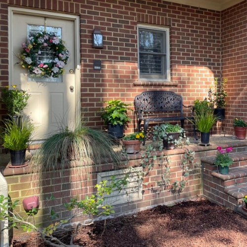 Balsam Hill Spring in Bloom Wreath hung on front door of red brick house