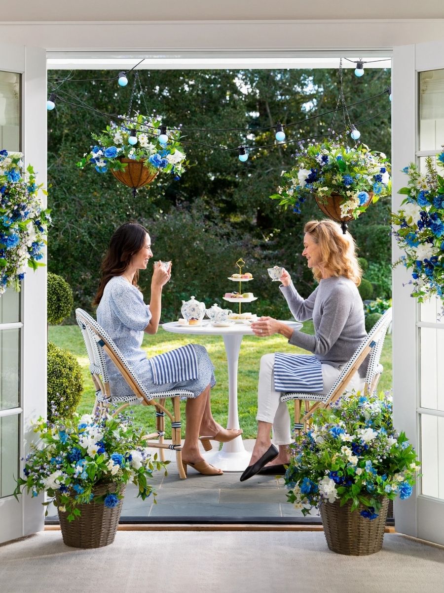Two ladies having afternoon tea amongst blue and white floral spring decorations