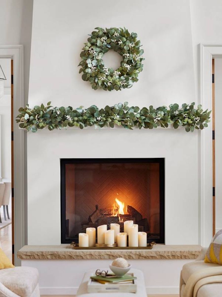 Minimalist spring theme featuring eucalyptus wreath and garland on a fireplace mantel