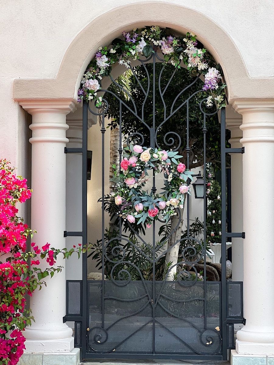 Gate decorated with a floral wreath and garland as spring decorating ideas