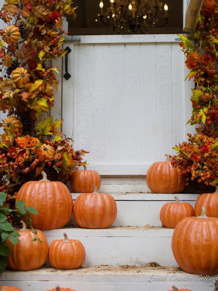 A cluster of orange pumpkins on porch steps as fall home decor