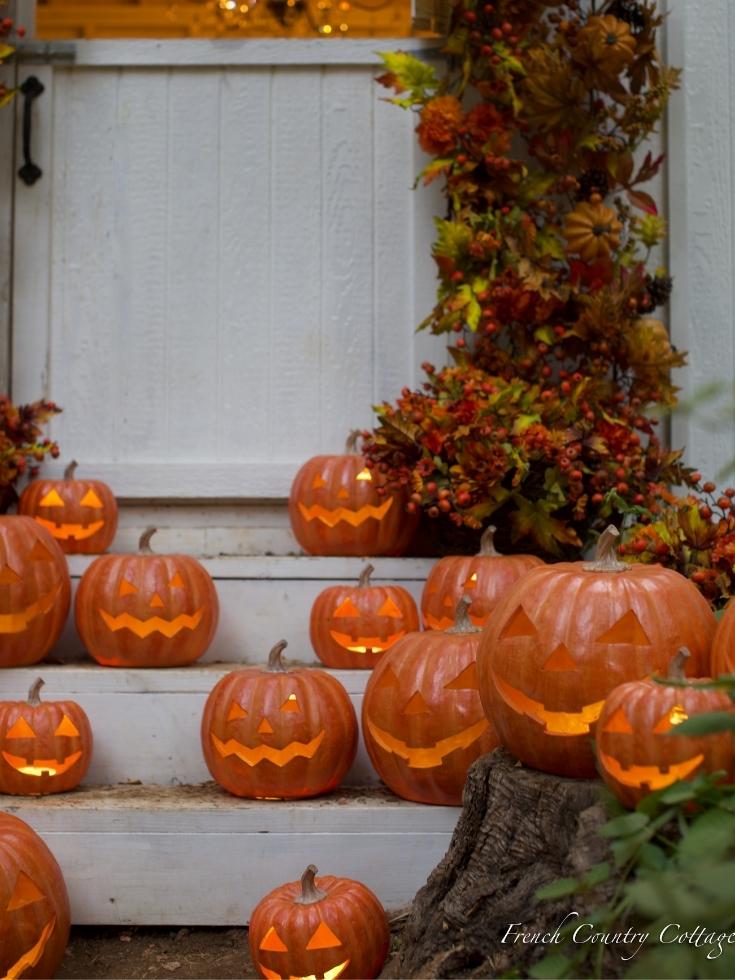 A group of Jack-o'-Lanterns by the porch steps as fall home decor