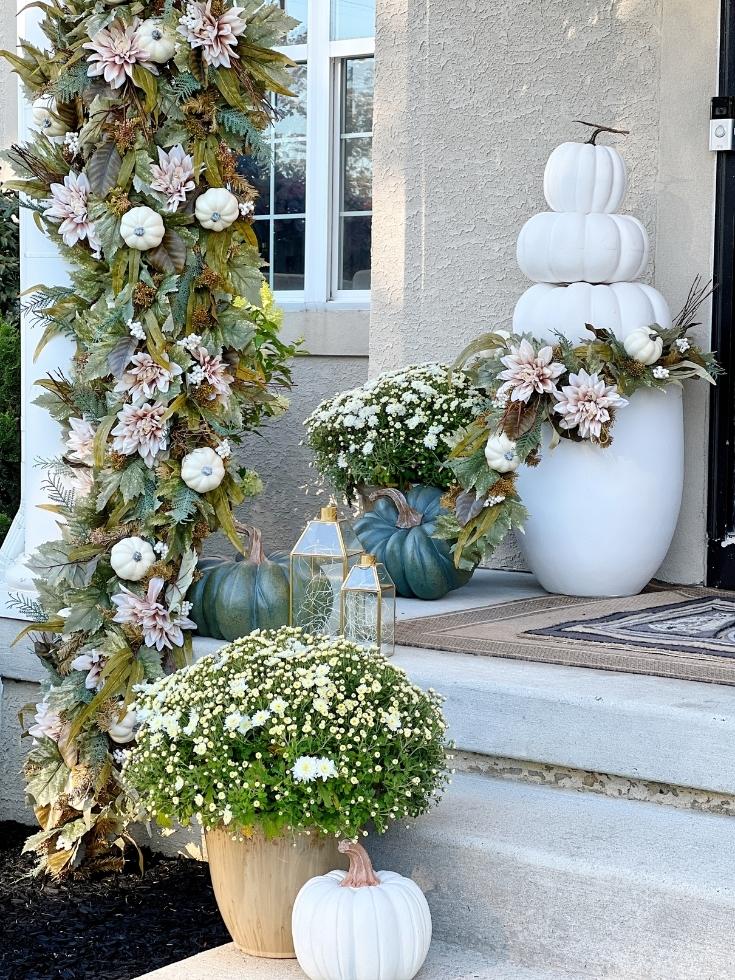 Front porch steps decorated with topiaries, white pumpkins, and fall garlands