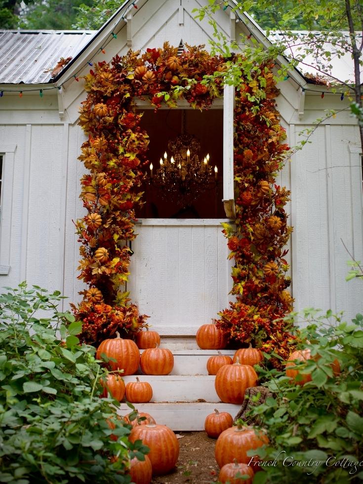 A backyard porch decorated with pumpkins and garlands embodying colors for fall