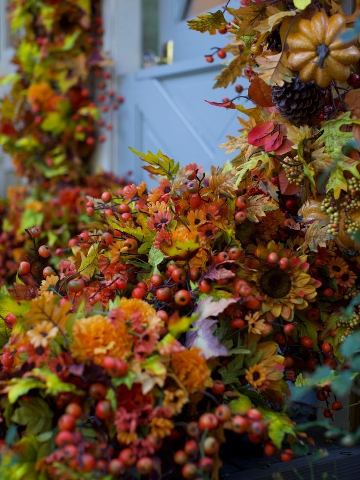 Autumn garlands with sunflowers, mums, berries, and pinecones in a deep fall color palette